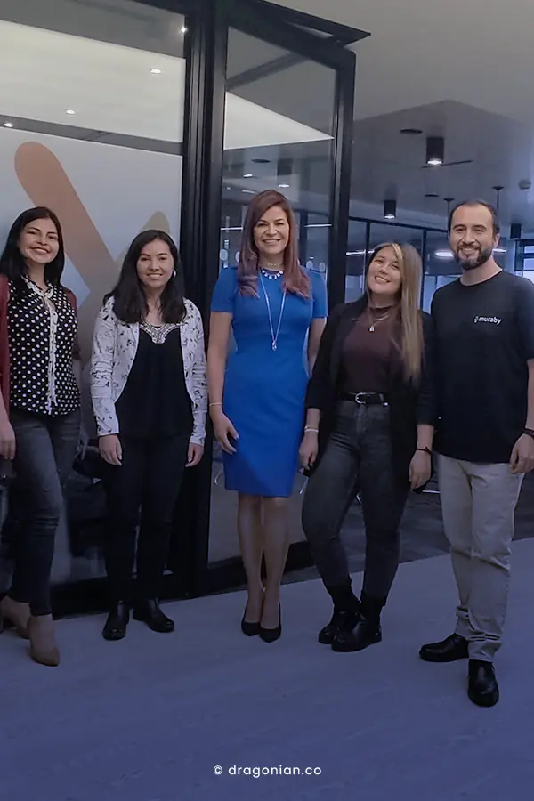 Grupo de trabajo tomandose foto en el ingreso de una empresa