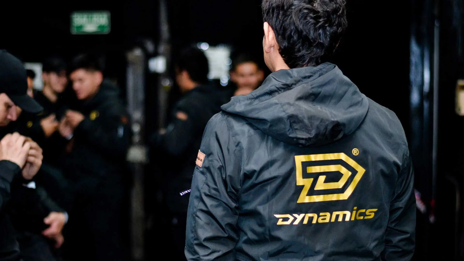 Hombre con chaqueta negra, mostrando espalda. Logo Dynamics Company por dRaGoNian